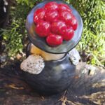 TF1002 Tonfigur Schwarzw&auml;lderin sitzend mit rotem Bollenhut